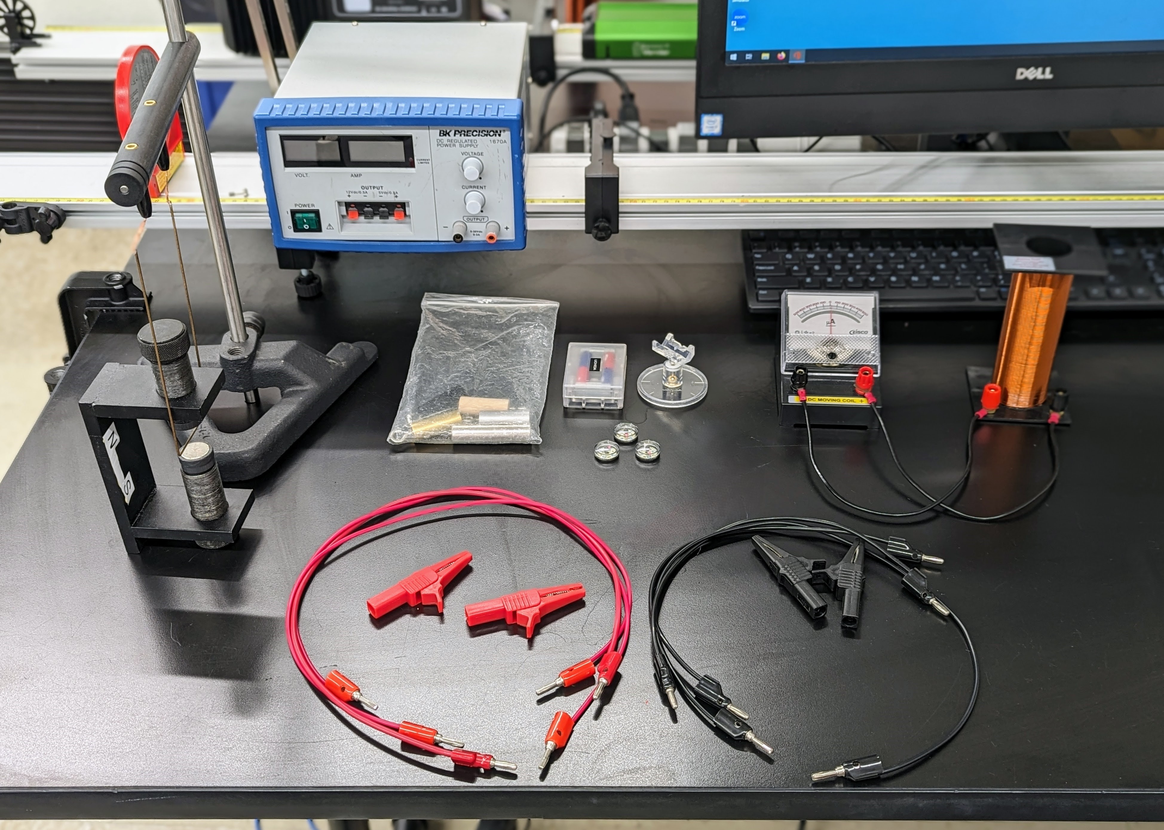 Whole Table Setup of the Magnetic Fields Lab. Galvanometer and Solenoid on the left, Trapeze Setup on the right connected to the power supply. Other Accessories are spread from left to right.