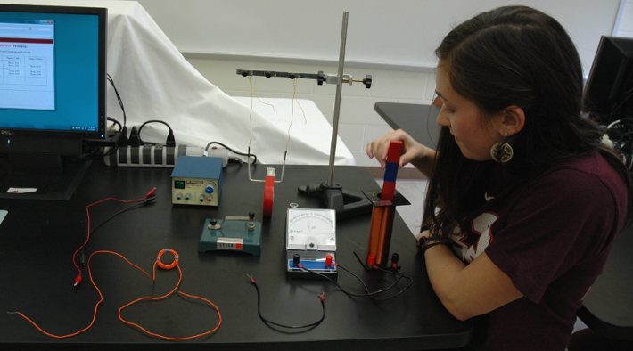 Rachel using the galvenometer to measure induced current with the old set up using the hedgehog power supply and hand made trapeze wire on the table as well.
